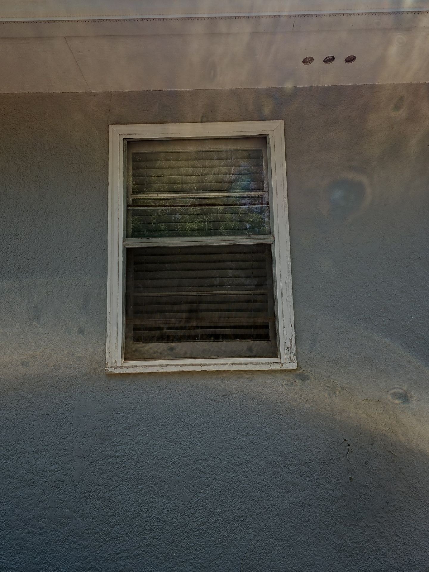 Before: close view of weathered window and deteriorated trim